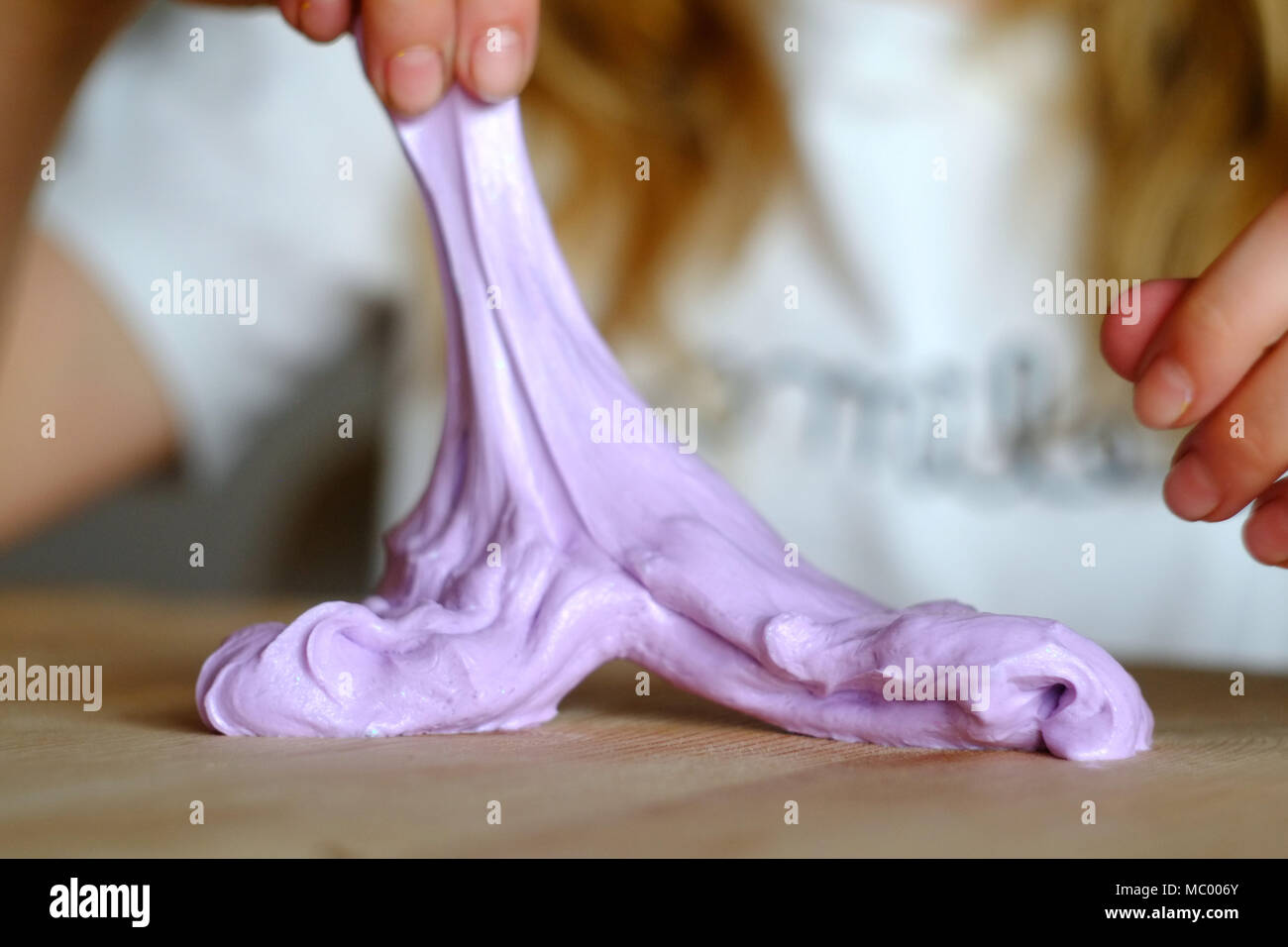 Child with home made slime. The new craze uses borax and PVA glue and paint to make colourful mixtures. Stock Photo