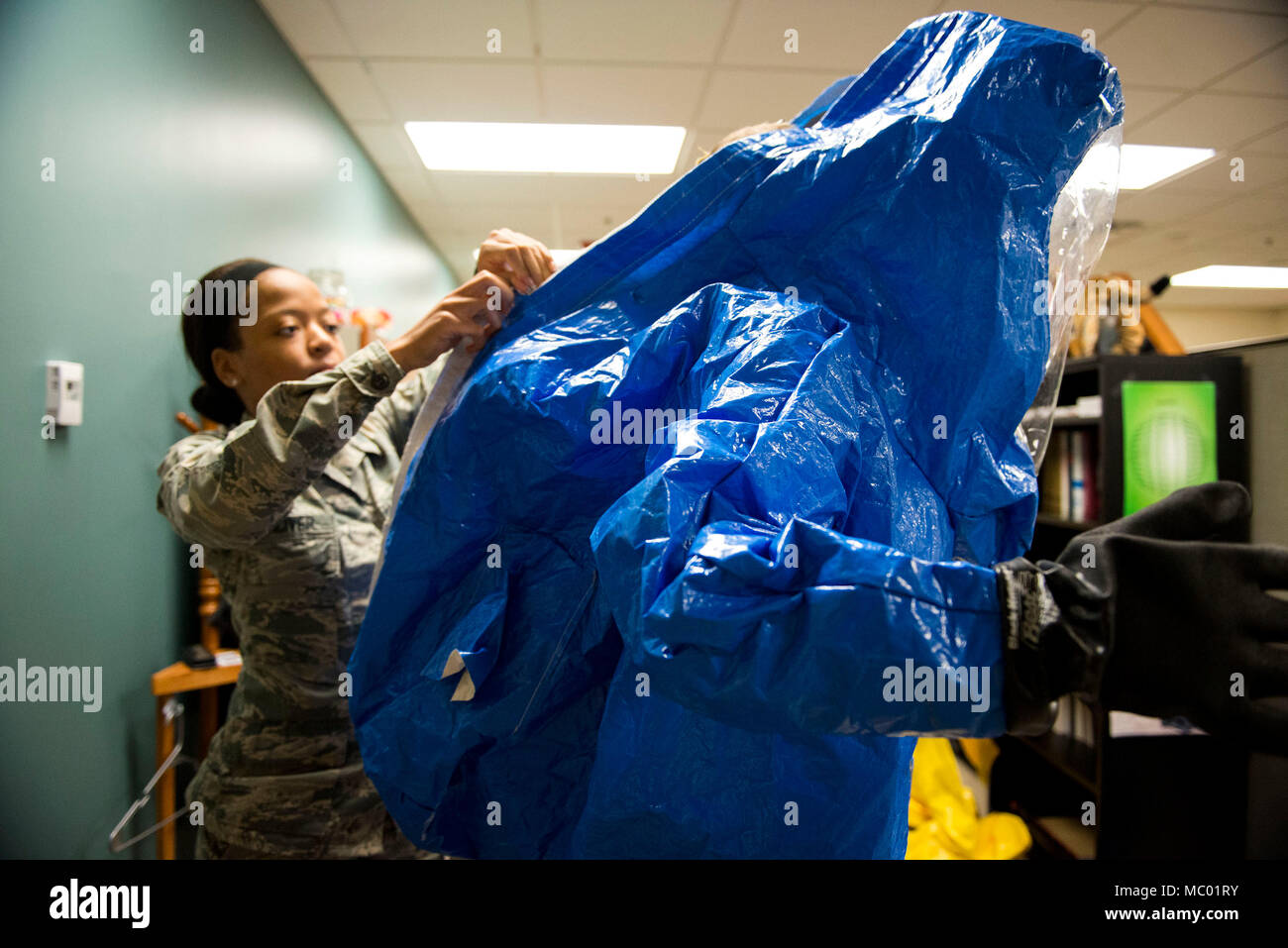 Airman 1st Class Briana McIver, left, 23d Aerospace Medicine Squadron (AMDS) bioenvironmental engineering apprentice, secures 2nd Lt. Eric Olson, 23d AMDS bioenvironmental engineer, in a Level A suit during readiness training, Jan. 12, 2018, at Moody Air Force Base, Ga. A Level A suit is designed to protect the user against any biological threat. The Bioenvironmental Engineering Flight tested their response capabilities in a simulated contamination scenario. Bioenvironmental engineering specialists focus on reducing health hazards in the workplace and surrounding areas. (U.S. Air Force photo b Stock Photo