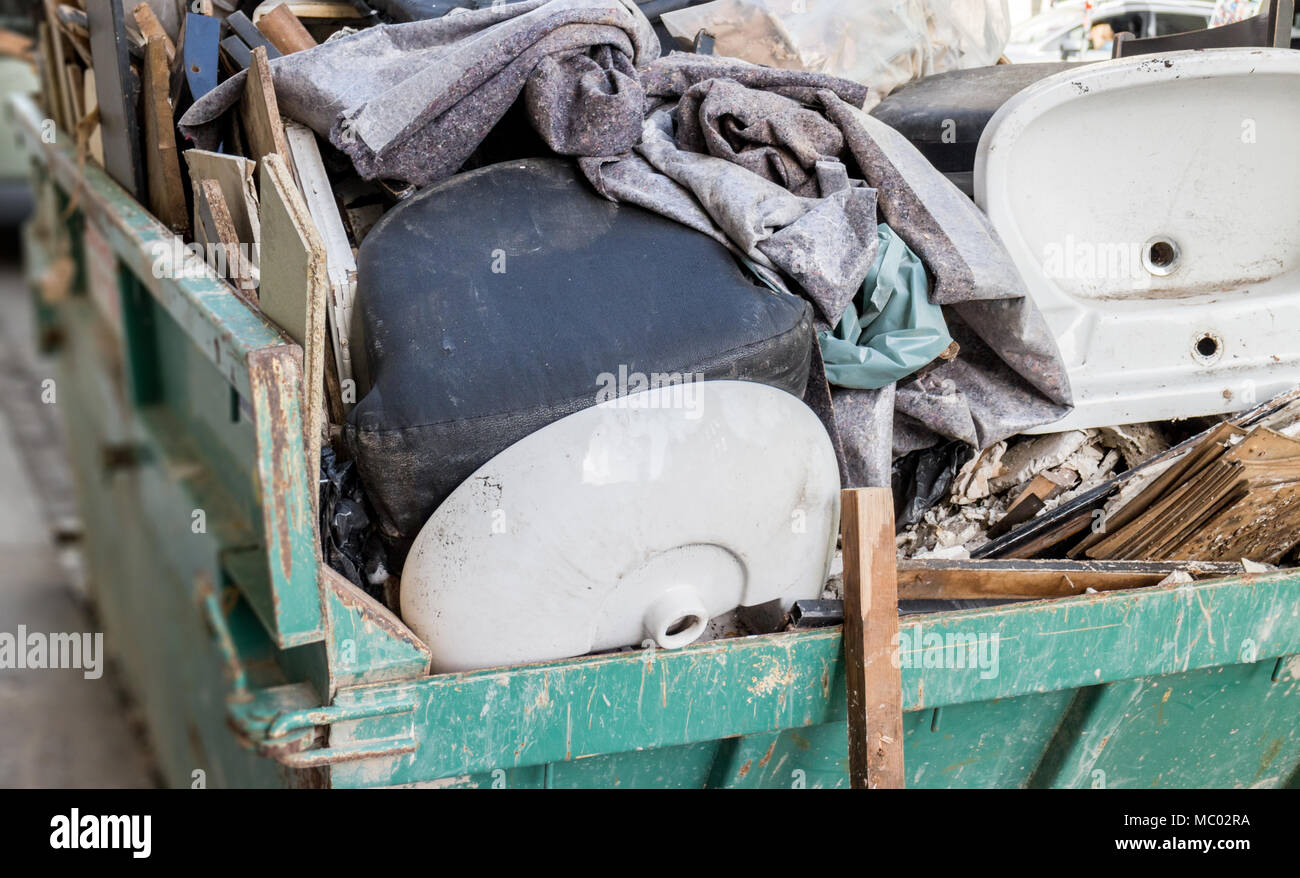 Big metal container with old household items, after renovation Stock Photo