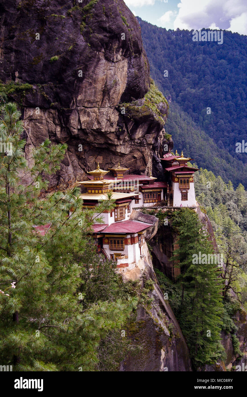 Taktsang Palphug Monastery or Tiger's Nest: Red and gold rooftops, perched on cliffside of the upper Paro valley, Bhutan Stock Photo