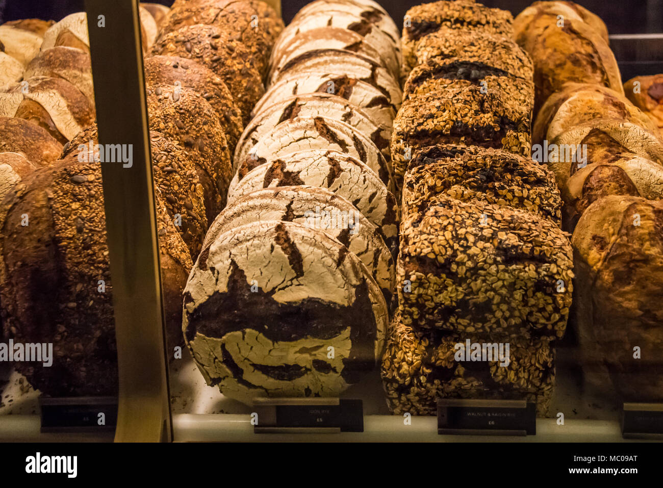 Variety of wholegrain breads arranged at a bakery window. Stock Photo