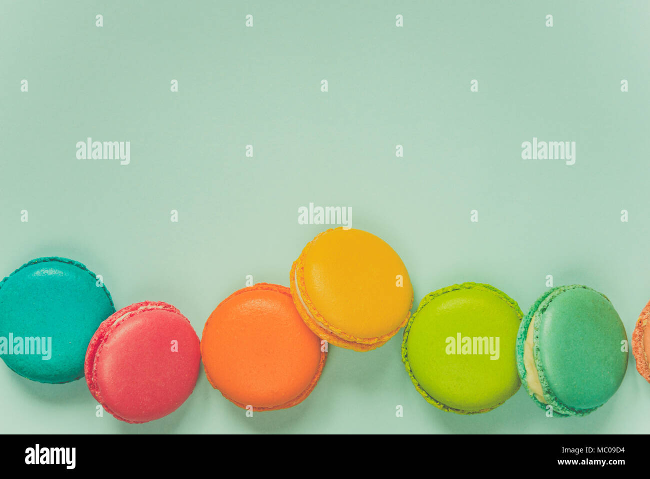 Colorful macaroons arranged over blue background. Copy space. Vintage effect. Stock Photo