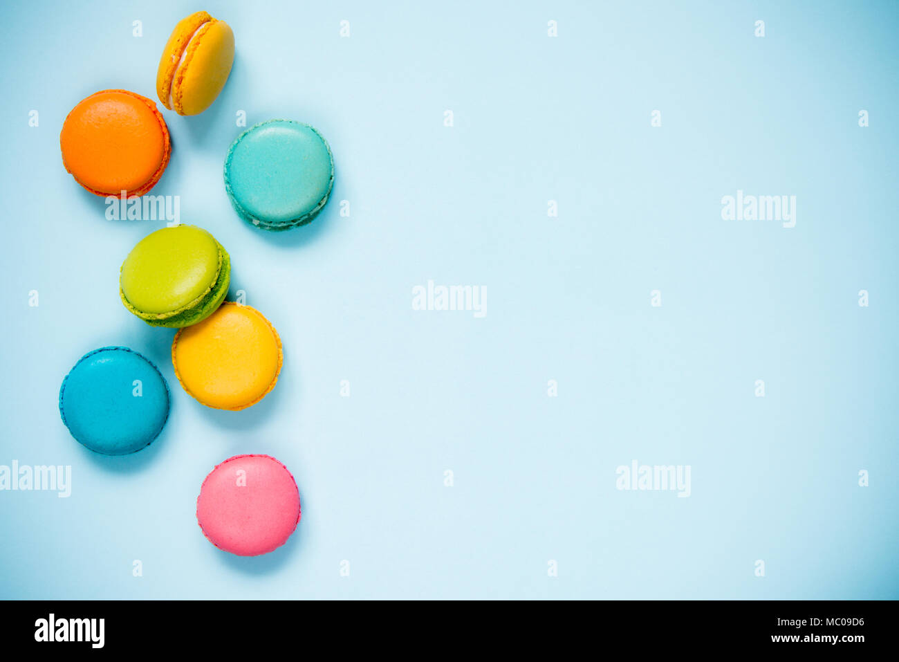 Colorful macaroons arranged over blue background. Copy space. Stock Photo