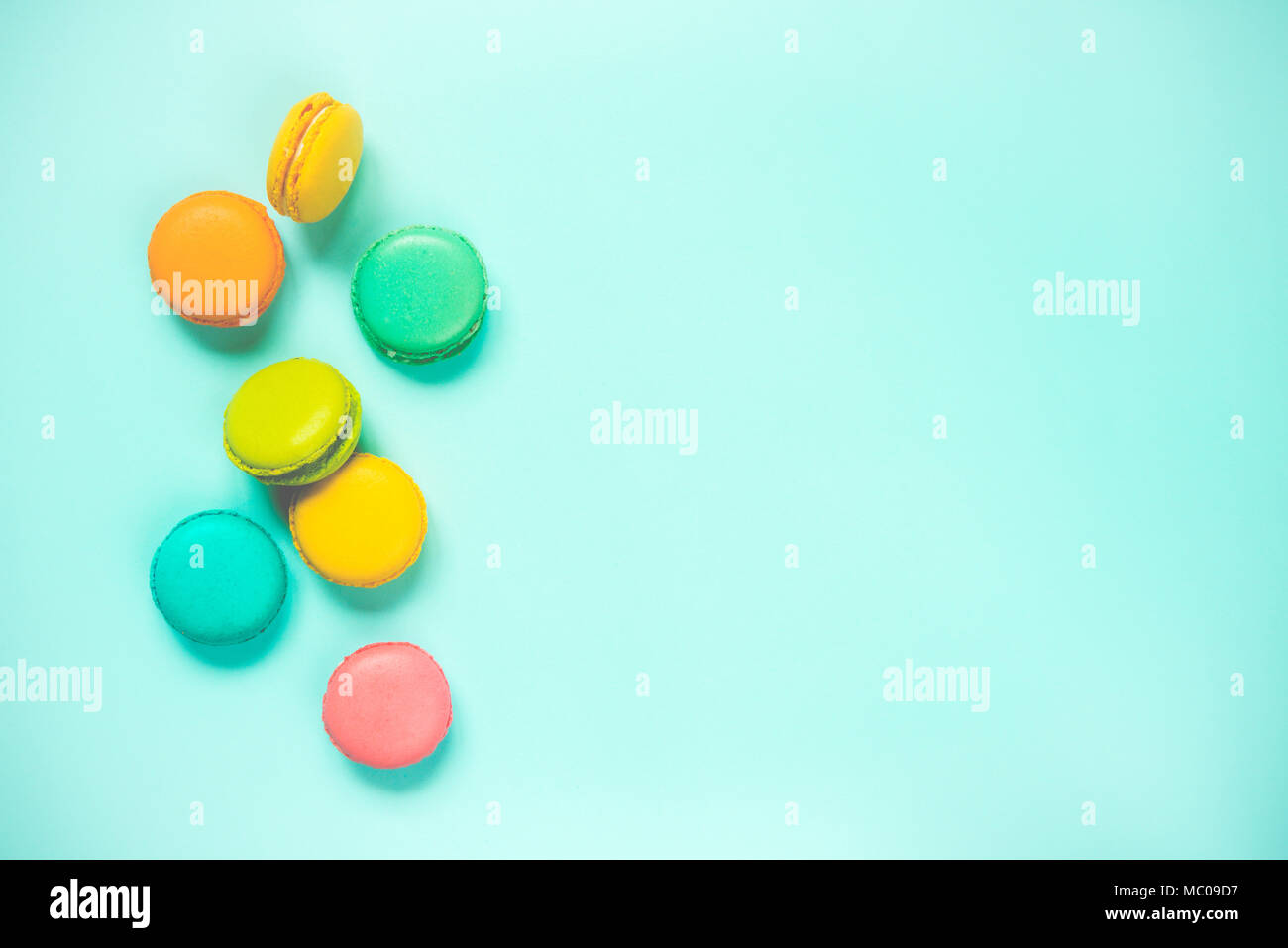 Colorful macaroons arranged over blue background. Copy space. Vintage effect. Stock Photo