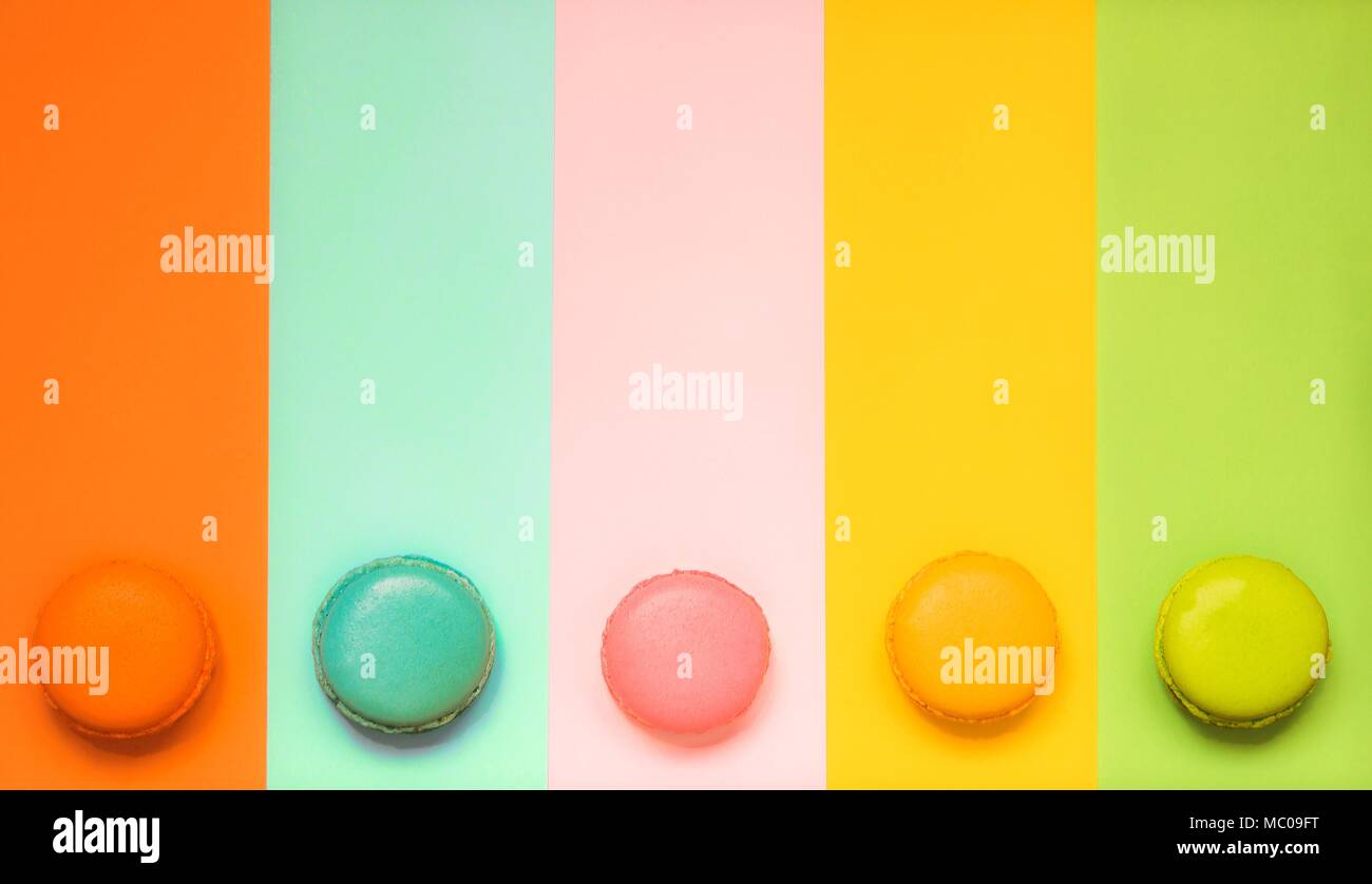 Various macaroons arranged over semi-colored background. Copy space. Vintage effect. Stock Photo