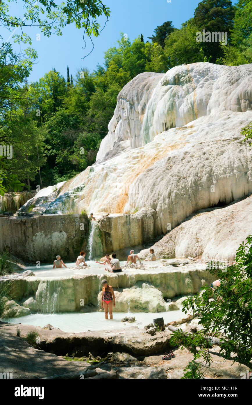 Local people enjoying the hot springs and travertine mineral pools at Fossa Bianca, White Whale, a volcanic waterfall in Bagni San Fillipo, Tuscany Stock Photo