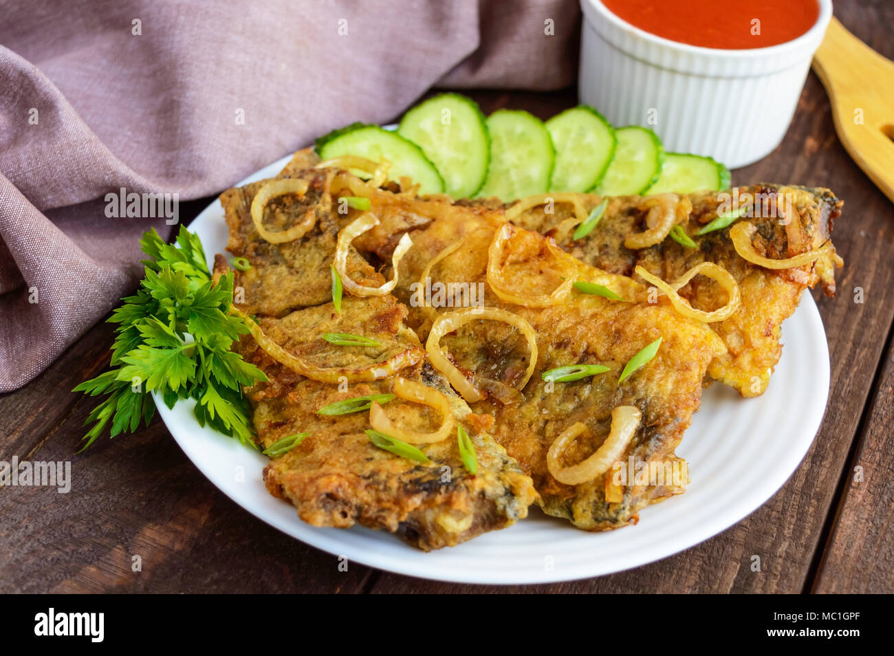 Fried carp fish fillet in batter on wooden table Stock Photo