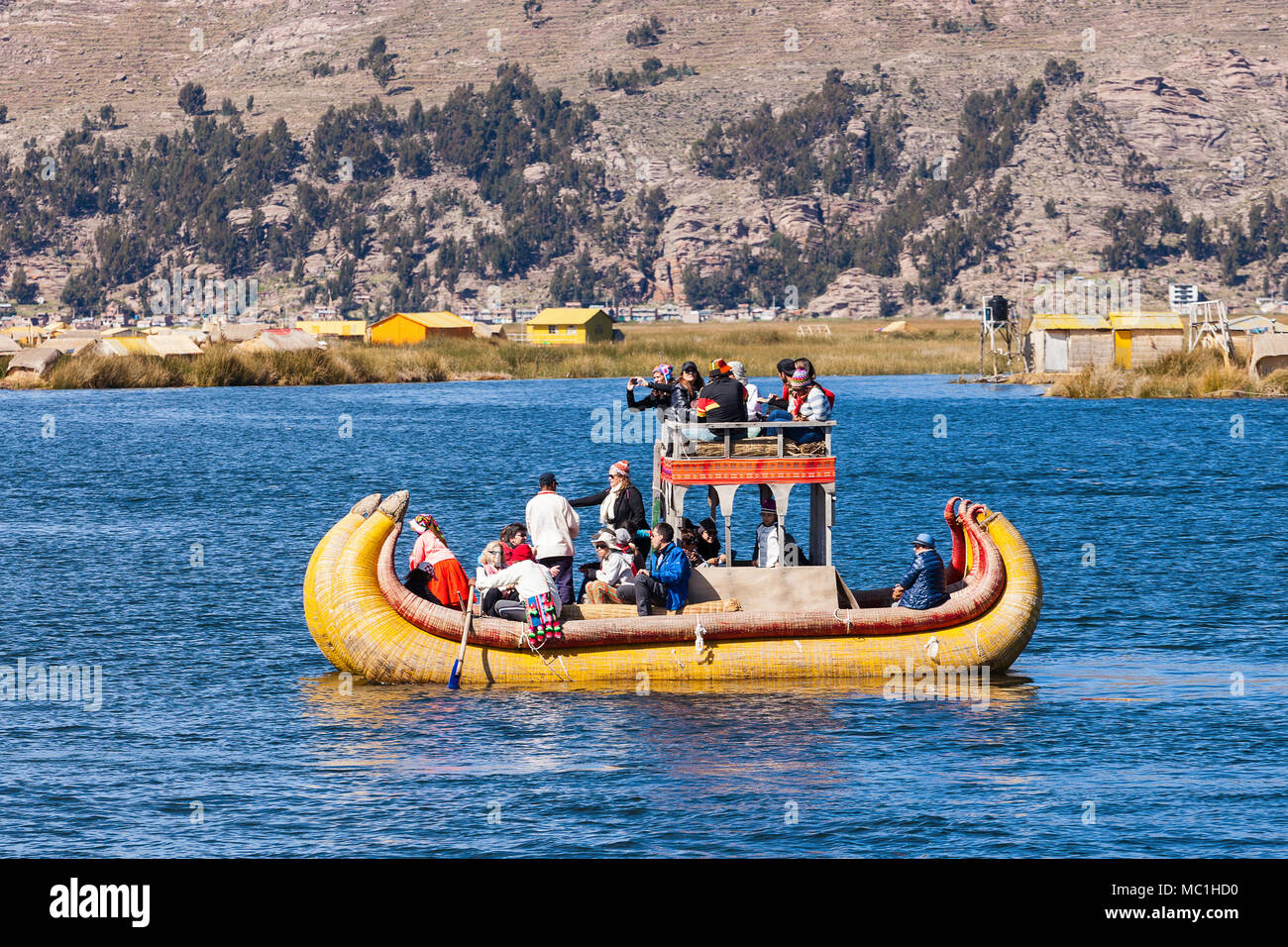 PUNO, PERU - MAY 14, 2015: Unidentified tourists in Totora boat, Titicaca lake near Puno, Peru Stock Photo