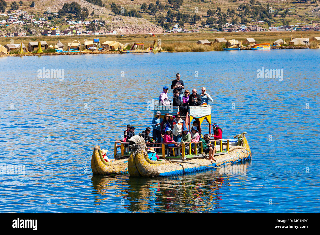 PUNO, PERU - MAY 14, 2015: Unidentified tourists in Totora boat, Titicaca lake near Puno, Peru Stock Photo
