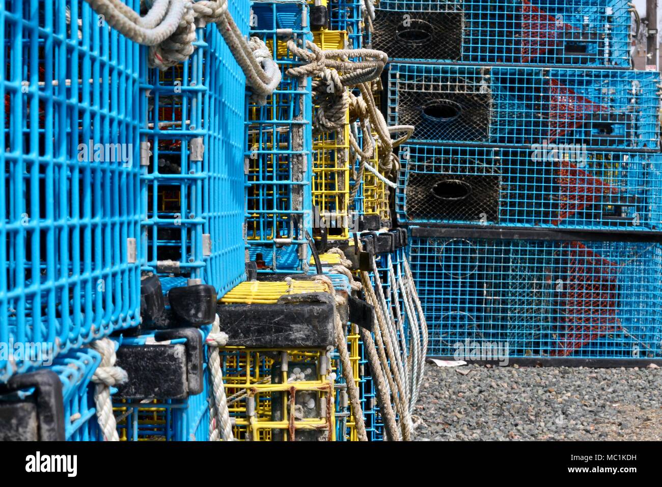 Side view of blue and yellow lobster traps on land, taken in Gloucester