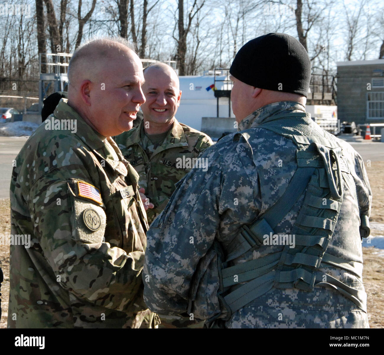 Major General Ray Shields (left), the commanderof the New York Army National Guard, congratulates Chief Warran Officer 5 Michael Johnson at the conclusion of his 'Final Flight' as an Army Pilot at Army Aviation Support Facility #3 in Latham, N.Y. on Jan. 25, 2018 as Col. Mark Slusar, the New York State Aviation Officer, looks on. Johnson celebrated his final flight after 35 years of service. ( U.S.Army National Guard Photo by Eric Durr) Stock Photo