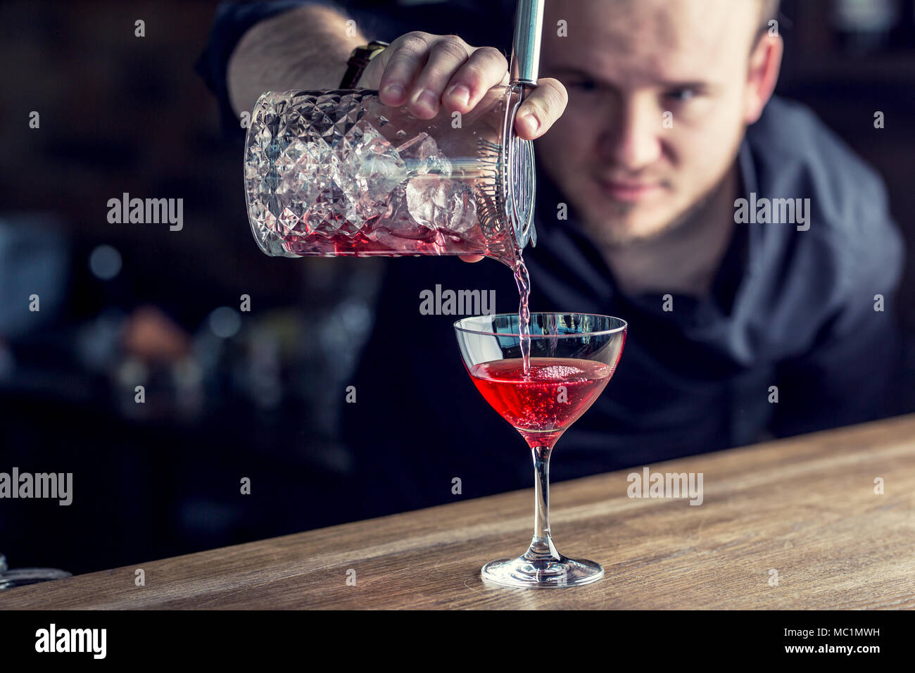 Barman in pub or restaurant  preparing a cocktail drink. Stock Photo