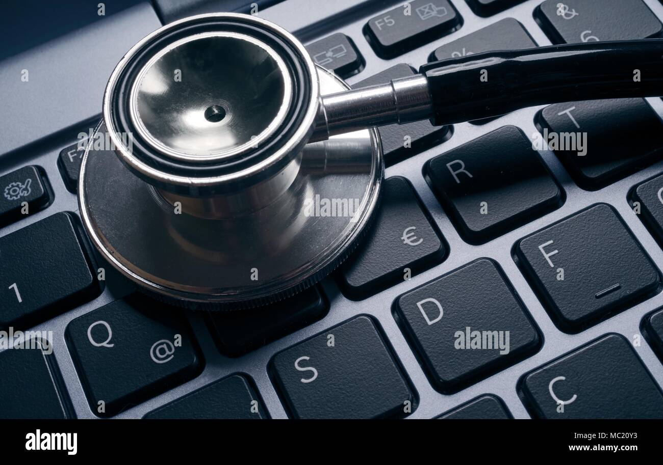 Computer virus concept image. Stethoscope lying on keyboard. Stock Photo