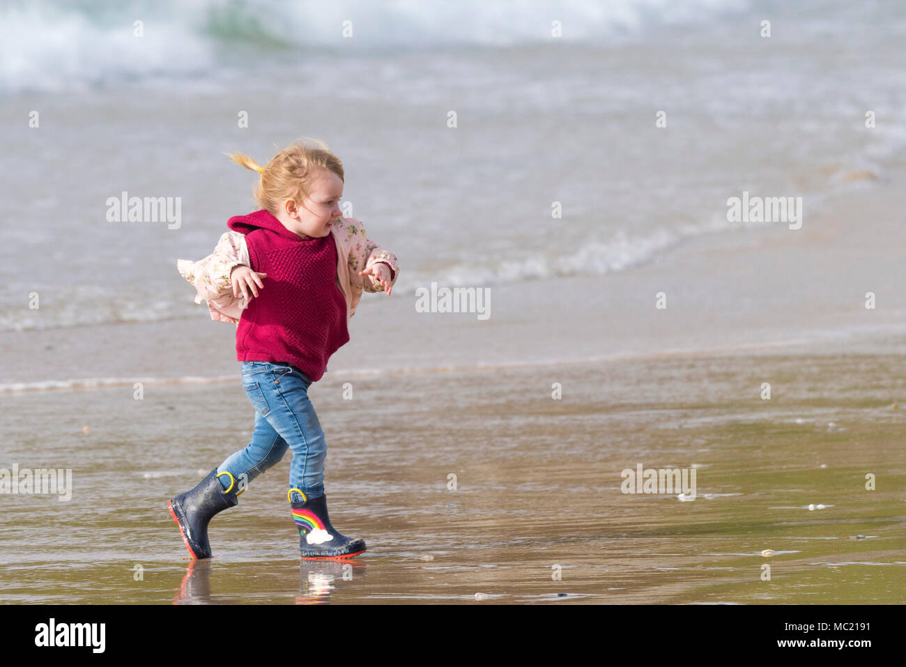 A little girl running on a Fistral beach in Newquay Cornwall. Stock Photo