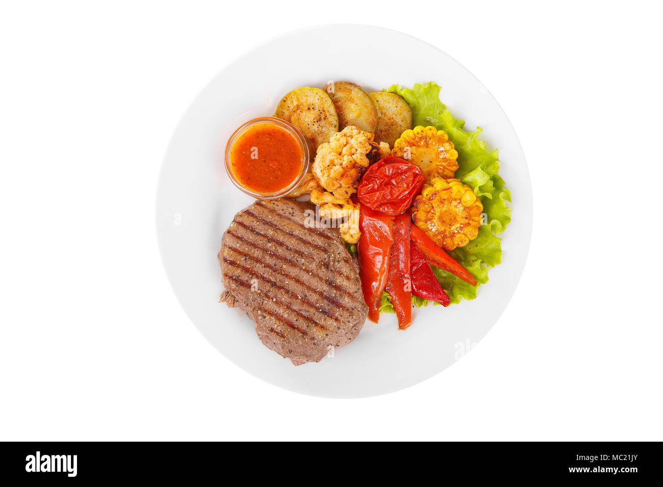 Steak beef, pork, lamb, grilled meat, barbecue with side dish vegetables on a plate isolated white background. Tomato, spicy, red sauce Juicy fillet,  Stock Photo