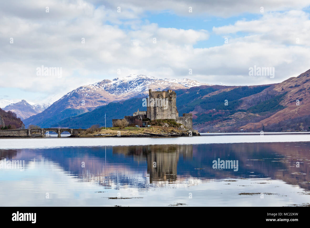 Eilean Donan Castle reflected in Loch Long at high tide, Dornie, Western Highlands, Scotland, UK in March Stock Photo
