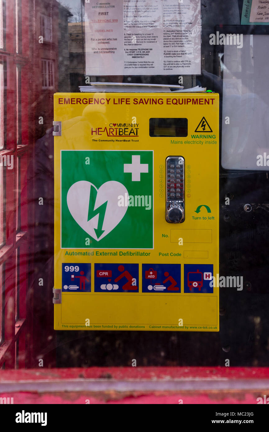 Disused red telephone box now converted to Defibrillator station for emergency, Avening, Gloucestershire, UK Stock Photo