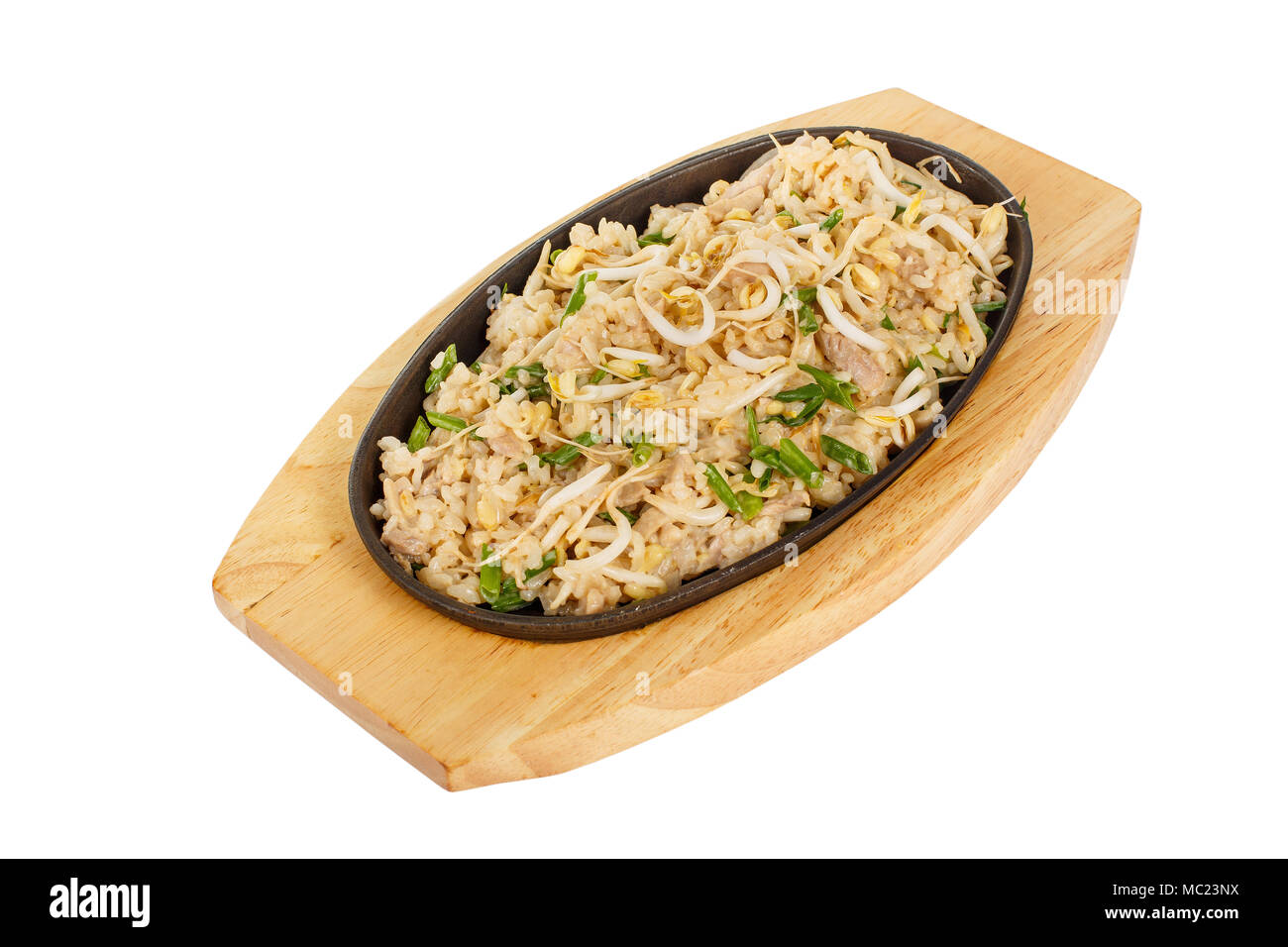 Kao pad rice with chicken, pork, with meat, sprouted soy, green onion, serving in hot frying pan, on wooden board on white isolated background side vi Stock Photo