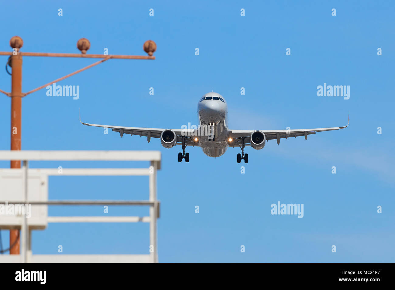 Airbus Passenger Plane On Final Approach Into Los Angeles International Airport, LAX, California, USA. An Approach Lighting Gantry In Foreground. Stock Photo