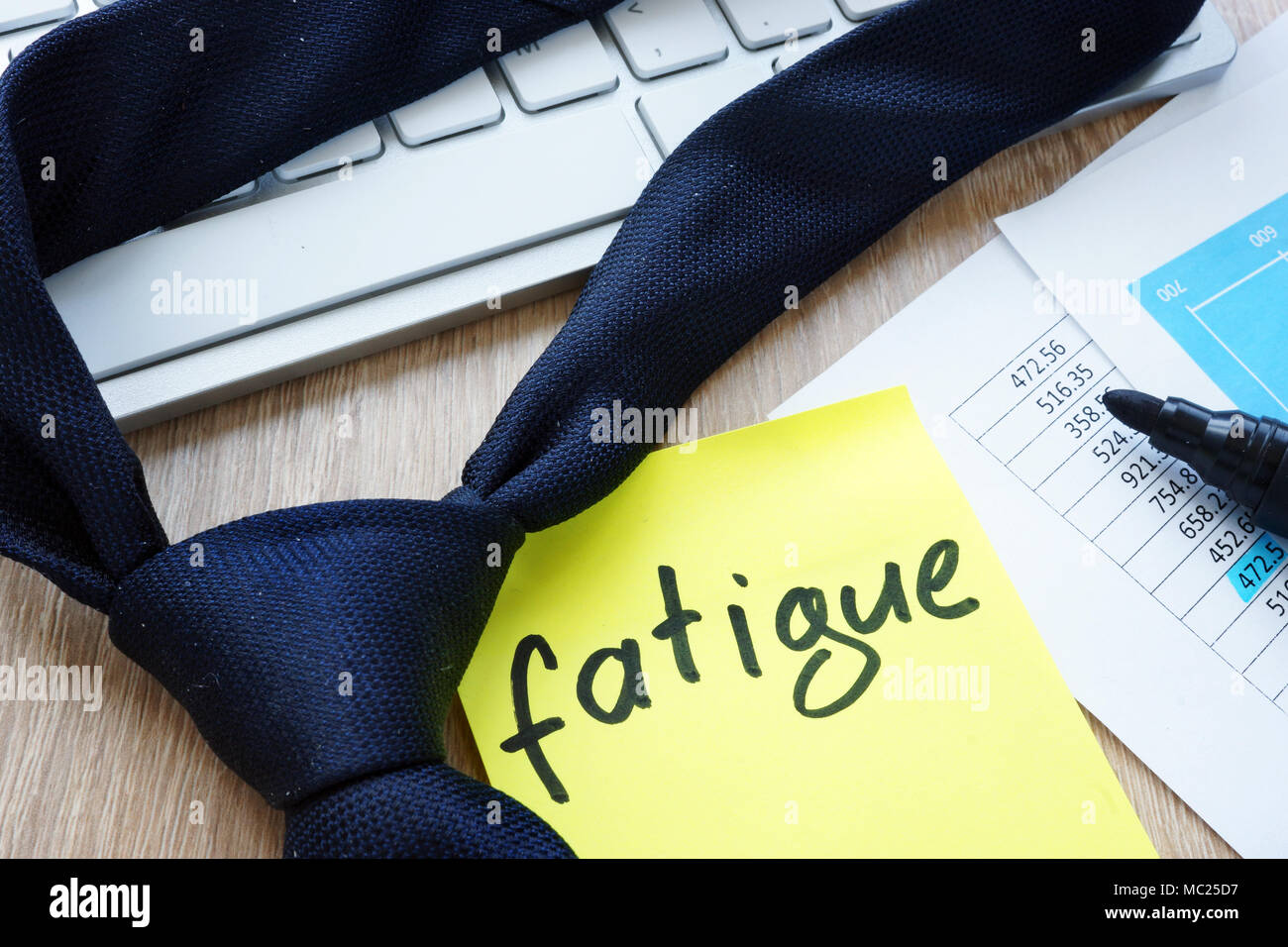 Tie and memo stick with word fatigue on an office desk. Stock Photo