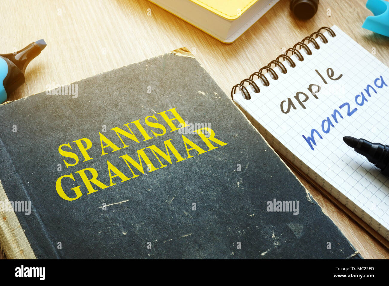 Learn Spanish grammar concept. Book and notebook on a desk Stock Photo