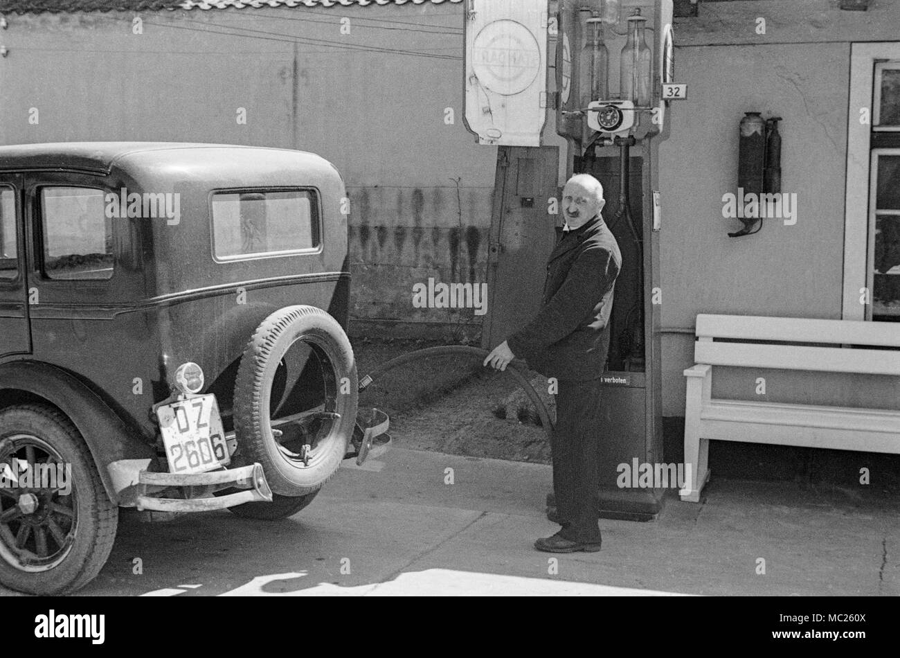Photograph taken in 1934 in Germany showing a man filling his car with petrol. Vintage black and white photograph. Stock Photo