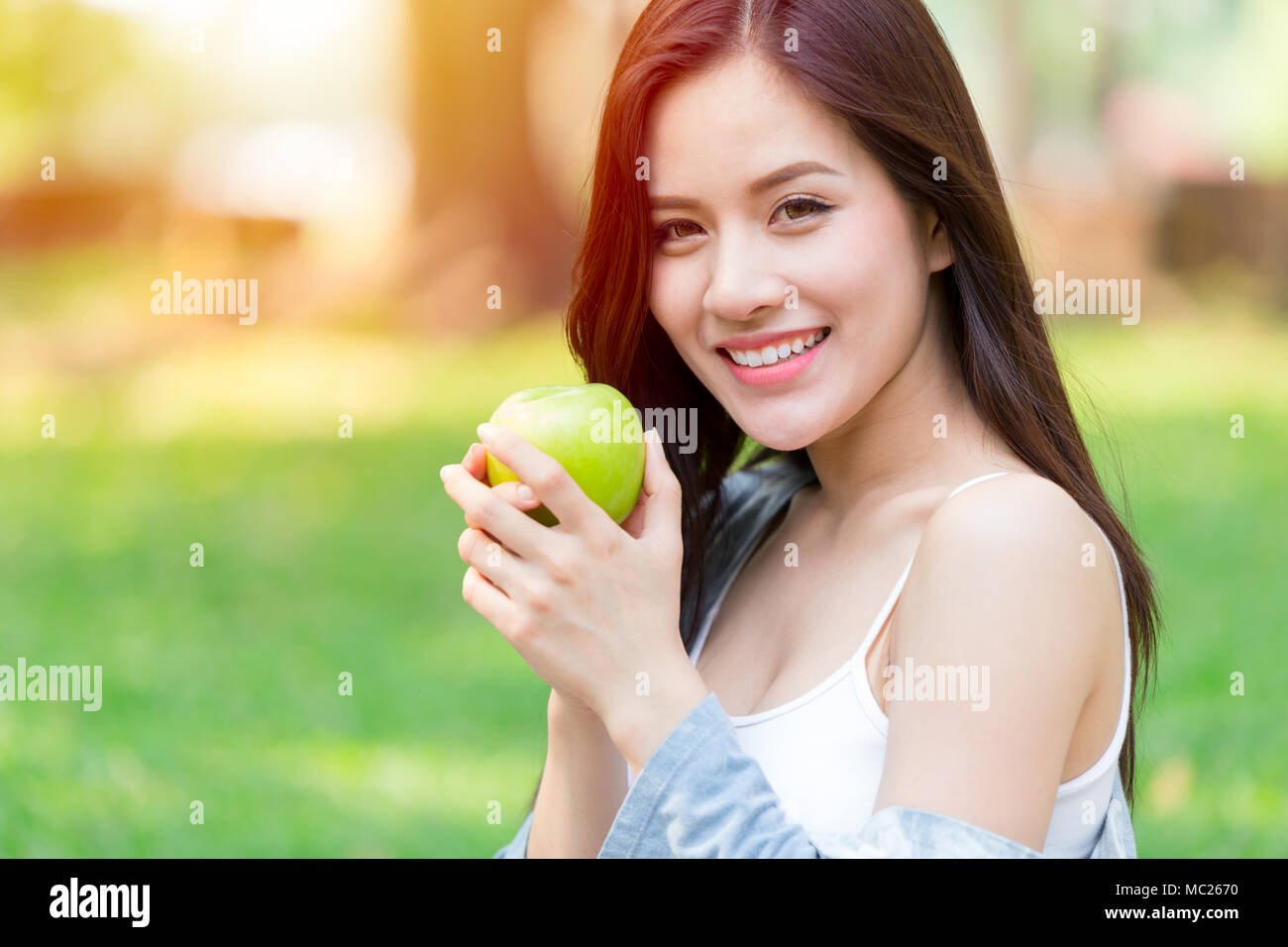 Beautiful Asian women model hand hold Green Apple in park outdoor healthy eating organic food fruits diet concept Stock Photo