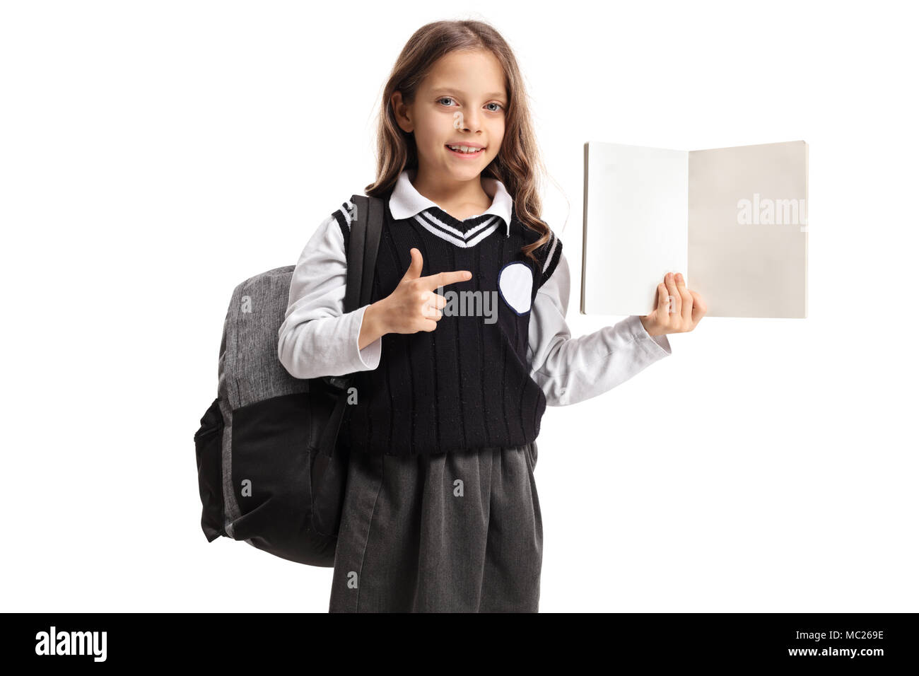 Schoolgirl holding a blank notebook and pointing isolated on white ...