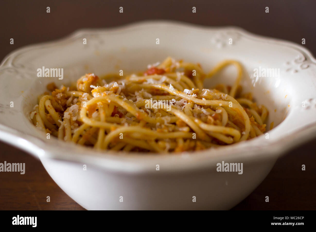 Plate of spaghetti with grated parmesan cheese on top Stock Photo