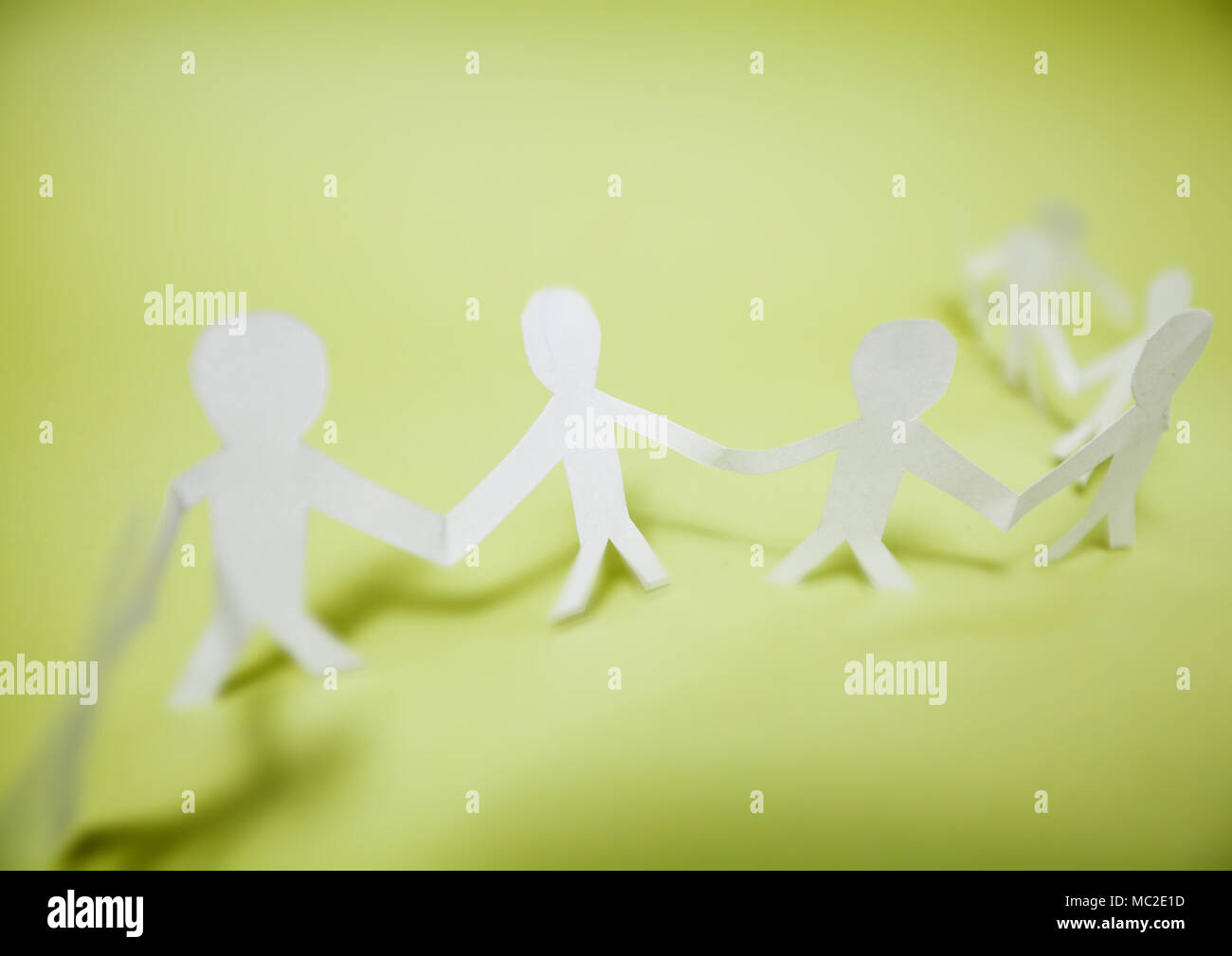 Connected support together, team paper doll people chain Stock Photo