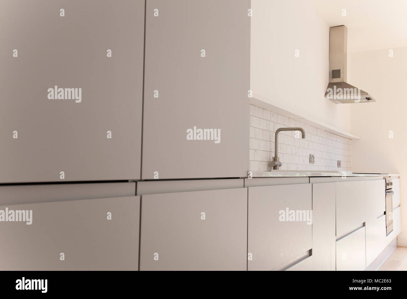 Modern kitchen interior with light grey cupboards Stock Photo - Alamy