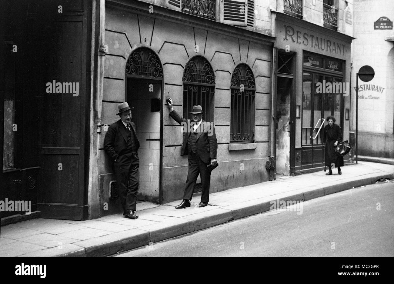 Men ringing door bell in Rue du Pelican, Paris, France in 1934 Stock Photo