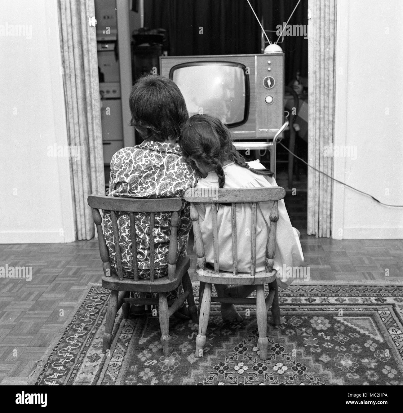 Two young children watch TV before bed-time in the UK, c1967.  Photograph by Tony Henshaw Stock Photo