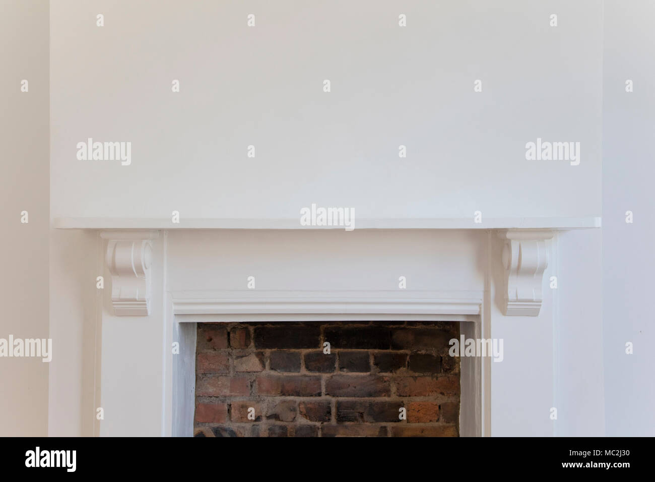 Victoriran Wooden Fireplace Surround With White Walls Stock Photo