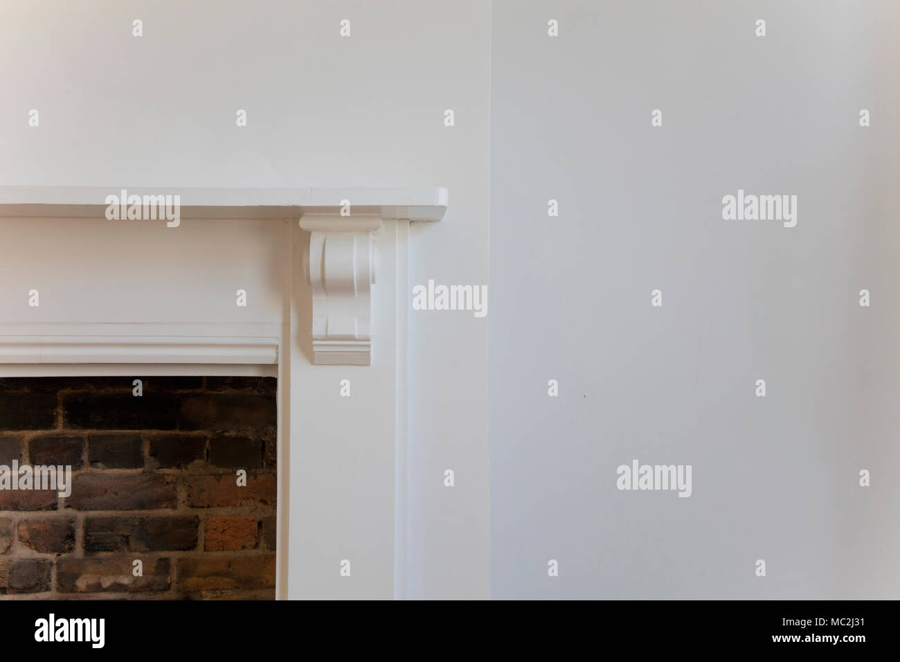 Victoriran Wooden Fireplace Surround With White Walls Stock Photo