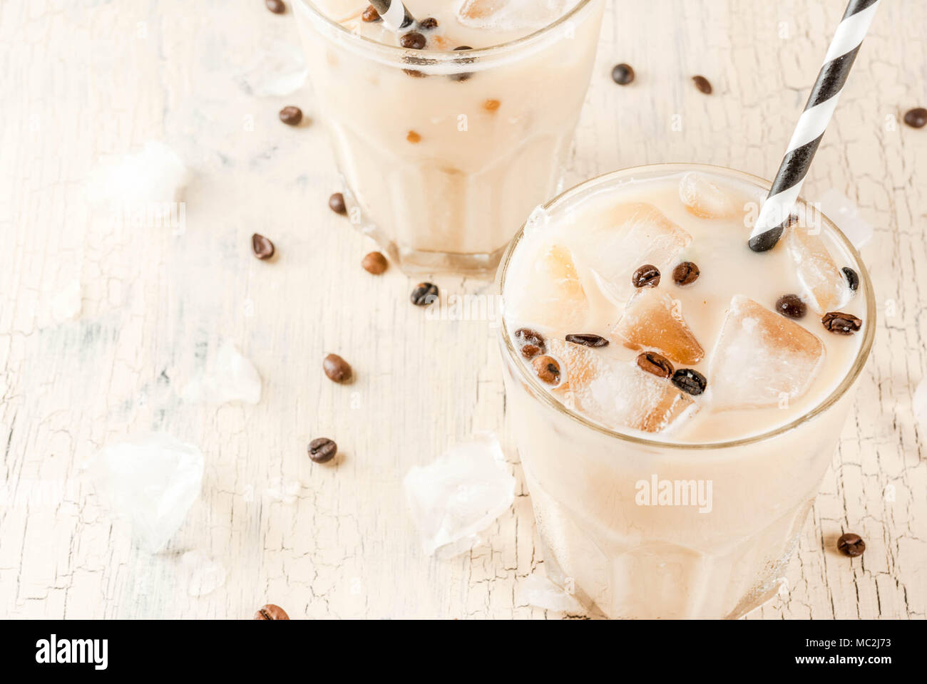 Summer cold Iced coffee frappe with milk and ice cubes, light concrete ...