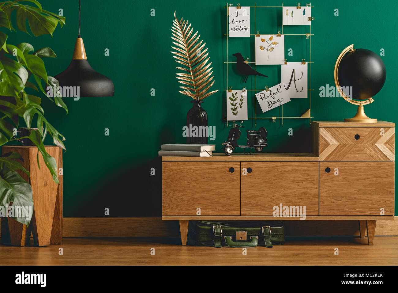Dark green apartment interior with scandinavian style wooden furniture and designer black and gold decorations Stock Photo