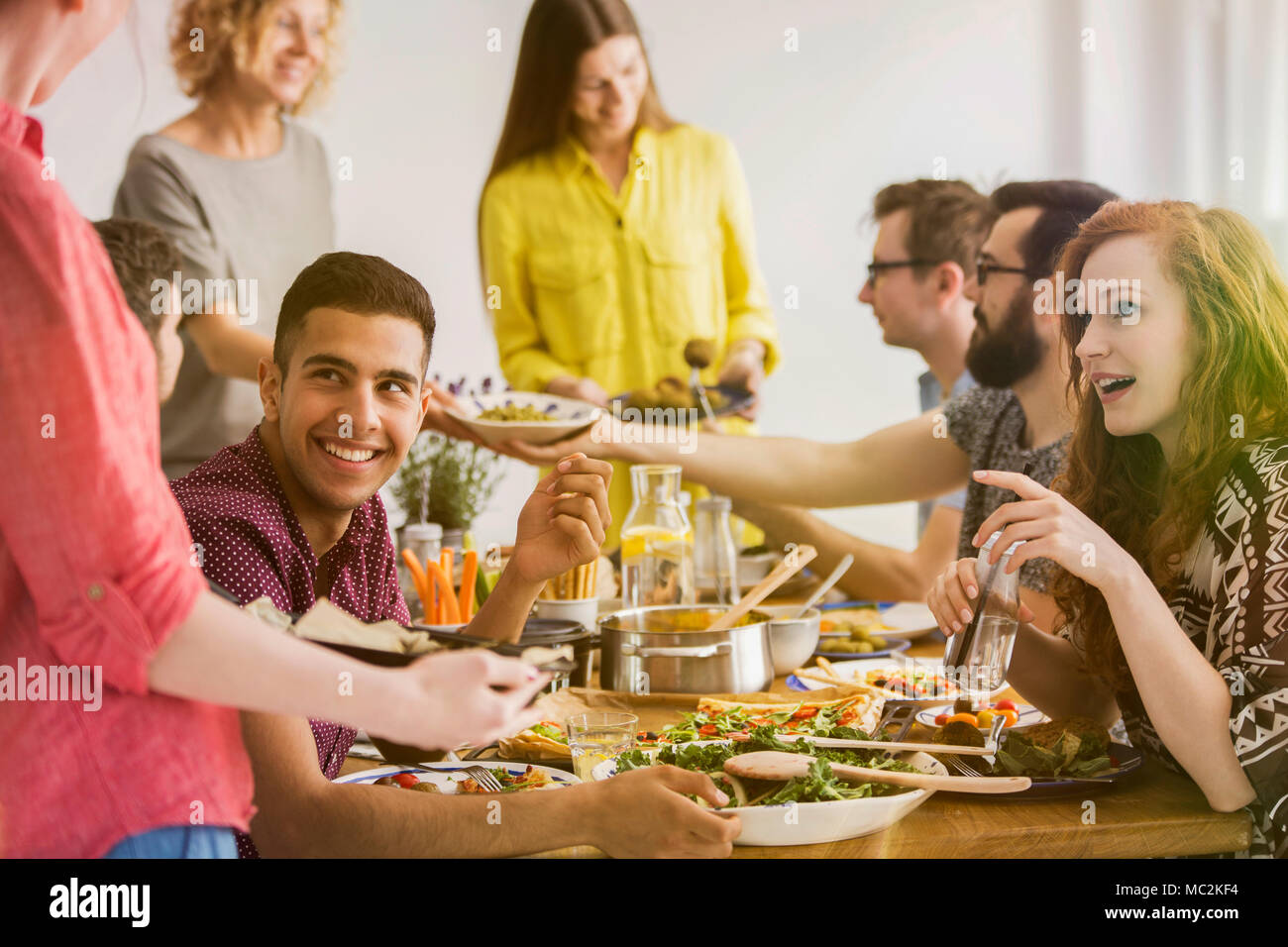 Group of vegan friends meeting and eating organic food in a restaurant Stock Photo