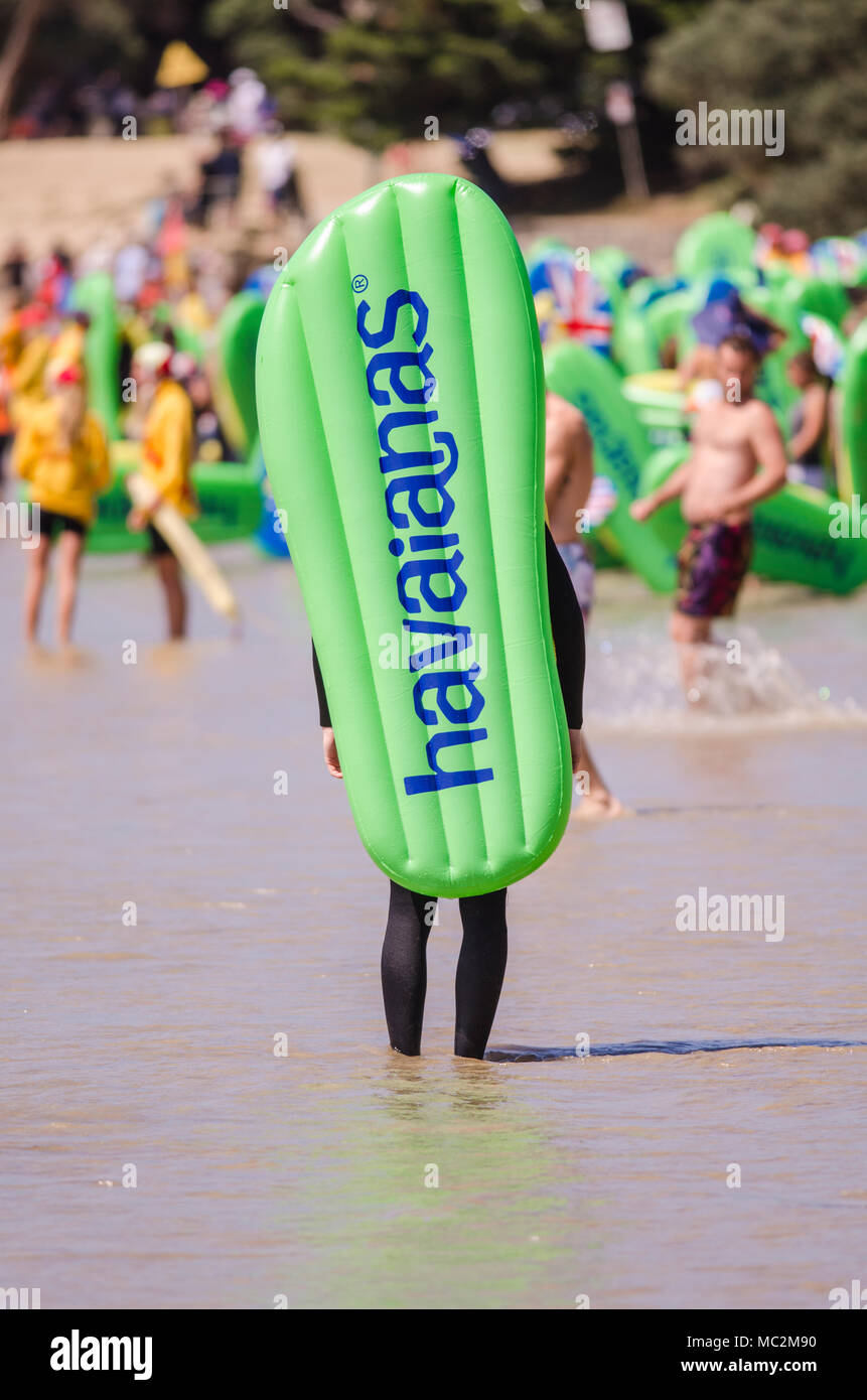 Beachgoers carrying inflatable Havianas flip flops into the surf at annual Australia Day event Cosy Corner Torquay Surf Coast Victoria Australia Stock Photo Alamy
