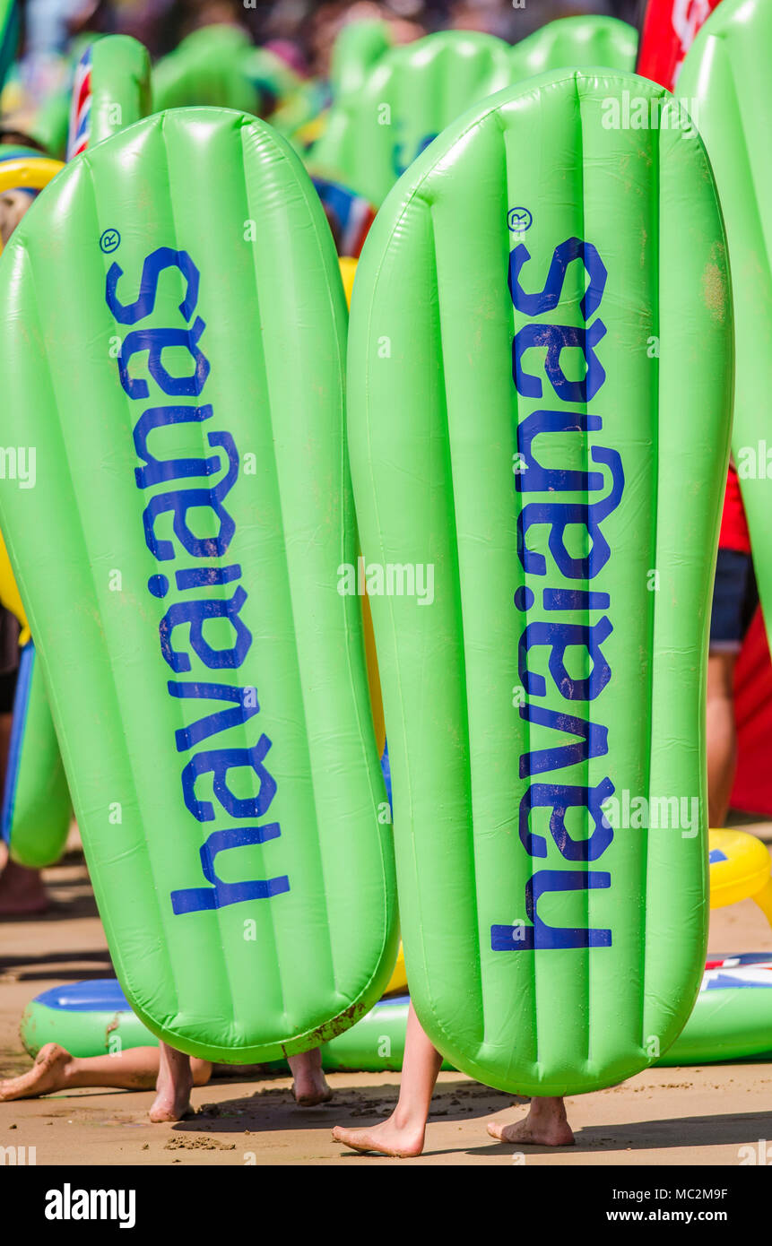 Beachgoers carrying inflatable Havianas 