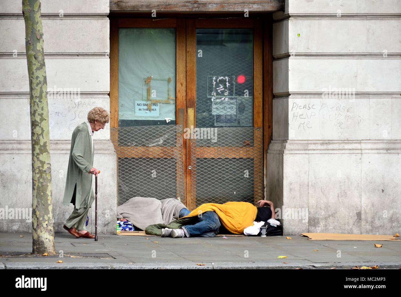 London, England, UK. Two homeless people sleeping in a doorway in St Martin's Place, near Trafalgar Square Stock Photo