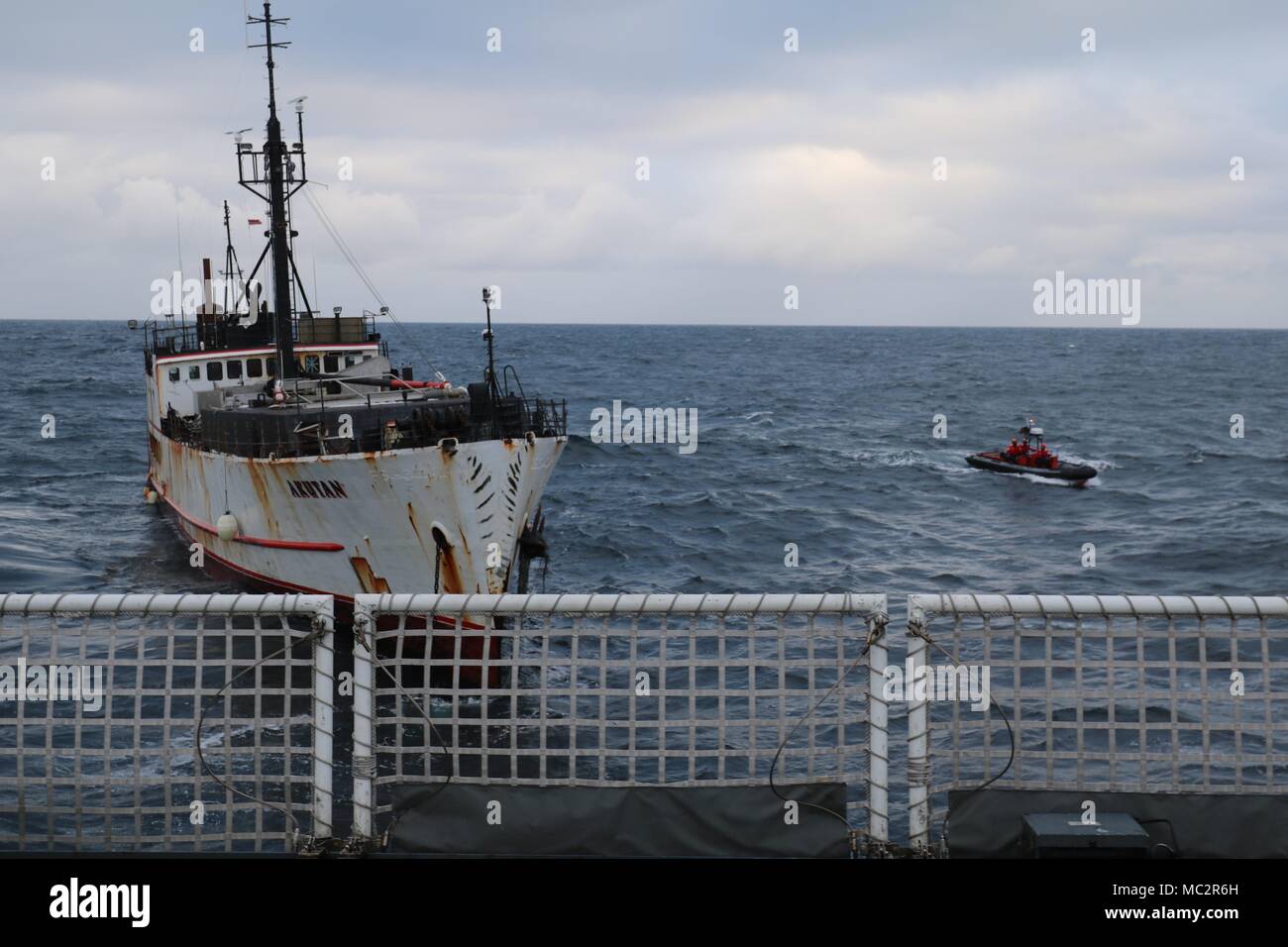 The crew of the Coast Guard Cutter Alex Haley prepares to break tow with the fishing vessel Akutan 25 nautical miles northwest of Dutch Harbor, Alaska, Jan. 25, 2018. In early January, the Alaska Department of Natural Resources requested Coast Guard assistance in towing the Akutan to a scuttling site after it was determined the abandoned vessel posed an emergency to life, property and the environment as it sat derelict, exposed to Bering Sea weather conditions. (U.S. Coast Guard photo by Lt.j.g. Matthew Schoen) Stock Photo