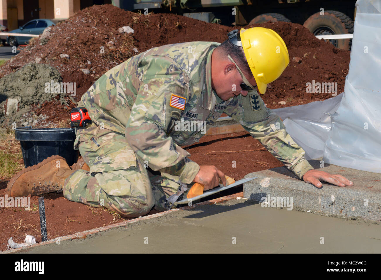 Staff Sgt. Landon Mears, a platoon leader assigned to the 561st Engineer Company, 84th Engineer Battalion, 130th Engineer Brigade, 8th Theater Sustainment Command, smooth’s a wet concrete surface at Schofield Barrack, Hawaii, on Jan. 26, 2018. Mears is part of a construction team laying the sidewalk and foundation for the 25th Infantry Division’s 3rd Brigade Combat Team Bronco Memorial can be placed in the vicinity. (U.S. Army photo by Staff Sgt. Armando R. Limon, 3rd Brigade Combat Team, 25th Infantry Division) Stock Photo