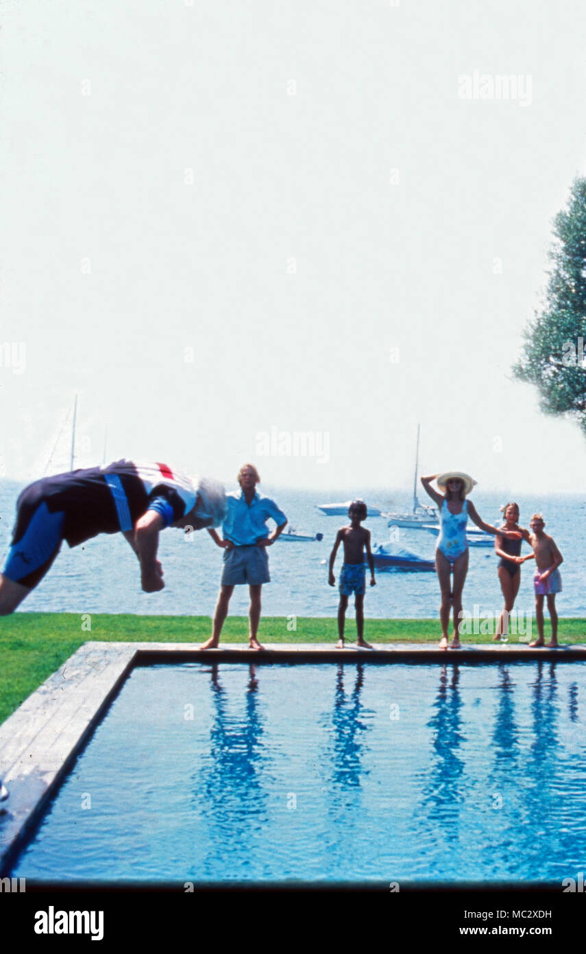 Familie Sachs hat Spaß, wenn Vater Gunter in den Pool springt. The Sachs family having fun when father Gunter jumps into the pool. Stock Photo