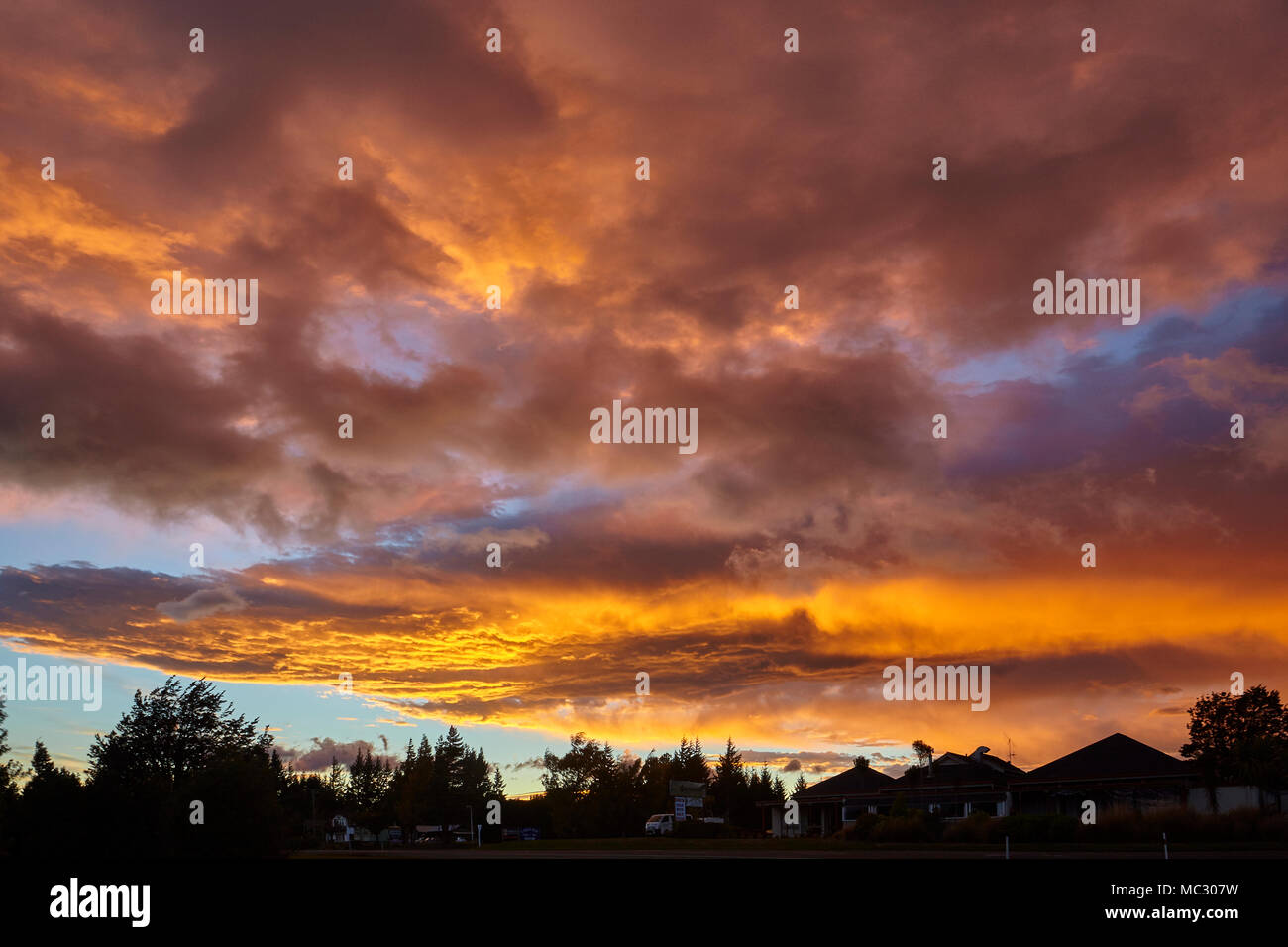 Orange and yellow colours of the sun lighting up the clouds during a ...
