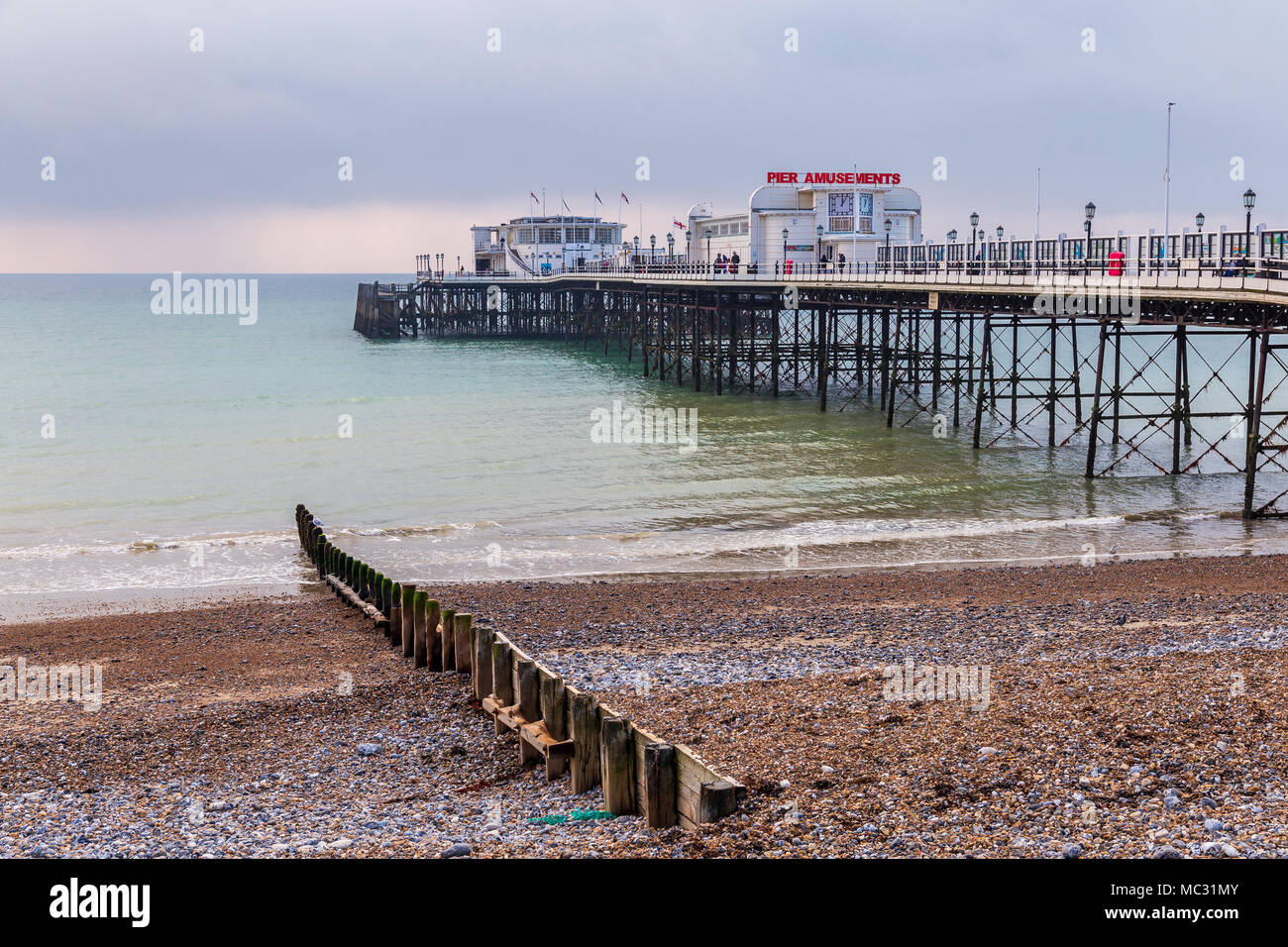 Worthing, West Sussex, England, UK - October 25, 2016: The pier seen from Worthing beach with grey clouds over the sea Stock Photo
