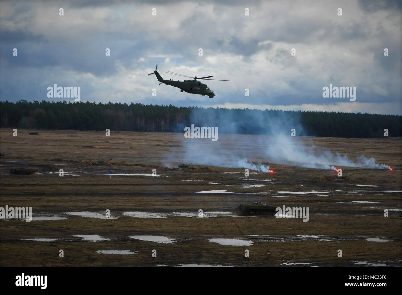 Mi-24 (Hind D) provides overhead protection for ground forces during the NATO Live Fire Exercise near Bemowo Piskie Training Area, Poland on Jan. 30, 2018. Battle Group Poland is a unique, multinational battle group, comprised of U.S., U.K., Croatian and Romanian soldiers who serve with the Polish 15th Mechanized Brigade as a deterrence force in northeast Poland in support of NATO’s Enhanced Forward Presence. (U.S. Army photo by Capt. Gary Loten-Beckford/ 22nd Mobile Public Affairs Detachment) Stock Photo