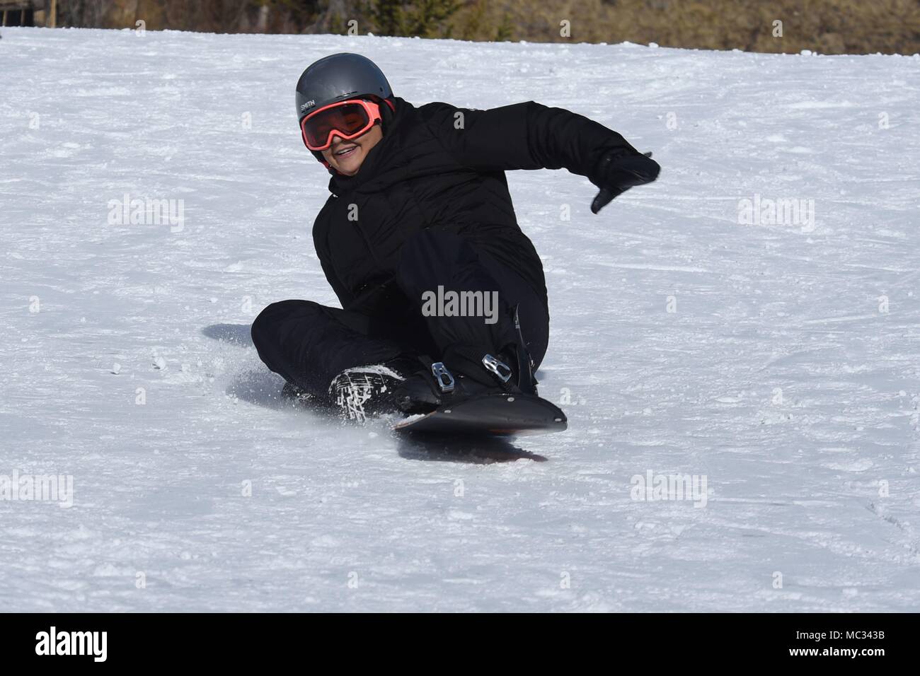 Senior Airman Emily Moreno, 50th Force Support Squadron career development journeyman, falls while snowboarding during the annual SnoFest at Copper Mountain, Colorado, Jan. 20, 2018. SnoFest brought Front Range military members together for a weekend of winter recreational activities. (U.S. Air Force photo by Airman 1st Class William Tracy) Stock Photo