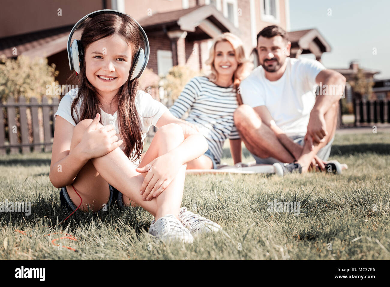Little pretty girl sitting and listening to music Stock Photo - Alamy