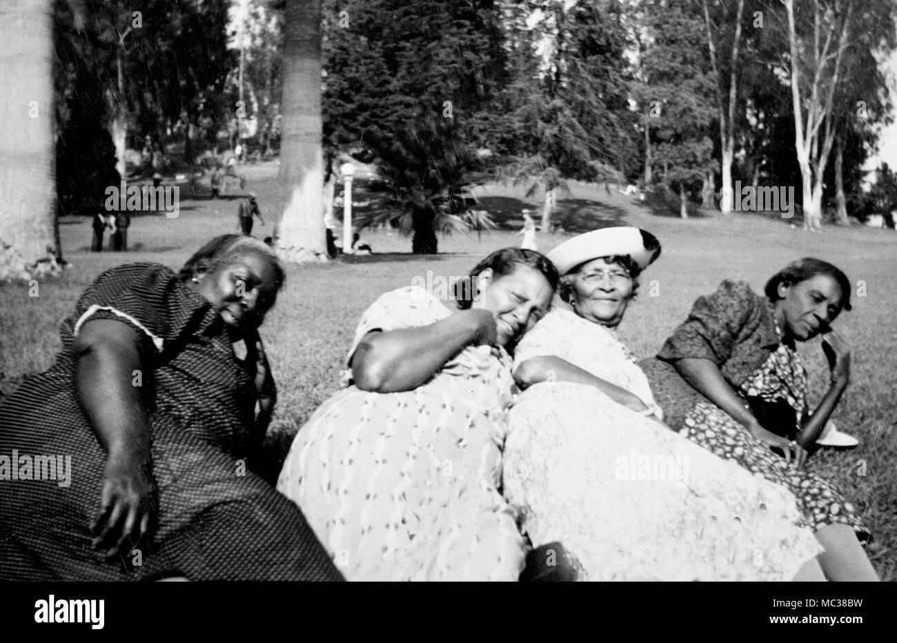 Four mature women lay on the grass in a Los Angeles, California park, ca.1941. Stock Photo